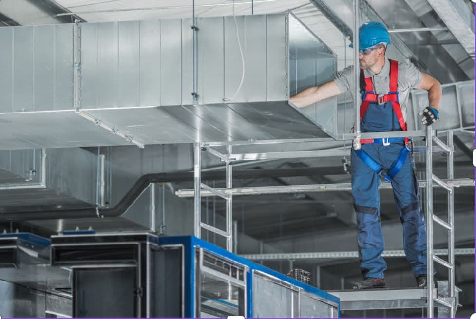 A commercial building with an HVAC worker